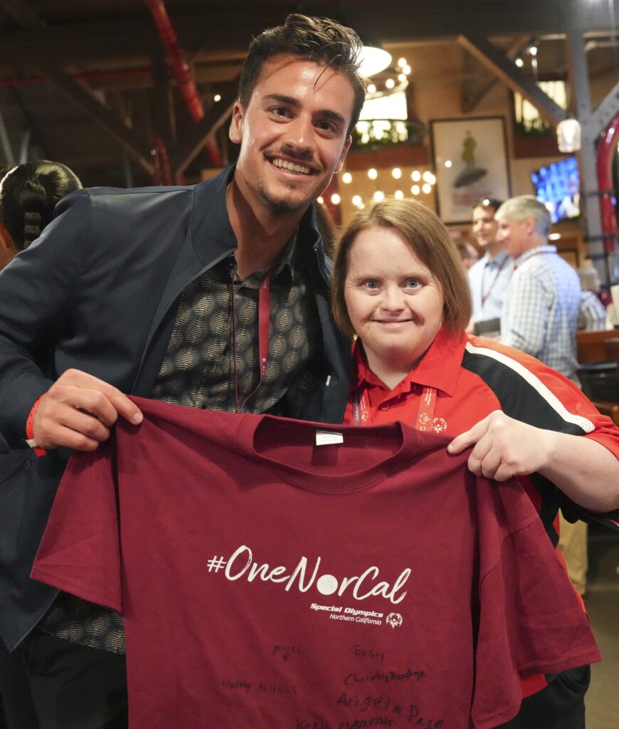 JT Marcinkowski holding a Special Olympics shirt with Special Olympics athlete Lindsay